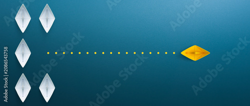 Business for innovative solution concept. Group of white paper ship in one direction and one yellow paper ship pointing in different way on blue background.