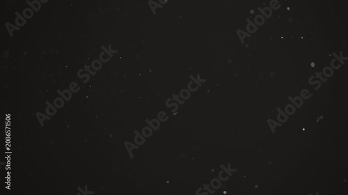 Floating dust particles over dark background with shallow focus