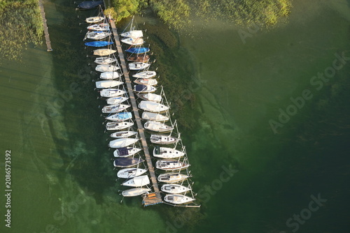 Obraz na plátně Bootsanlegestelle am Starnberger See in der Morgensonne aus der Vogelperspektive