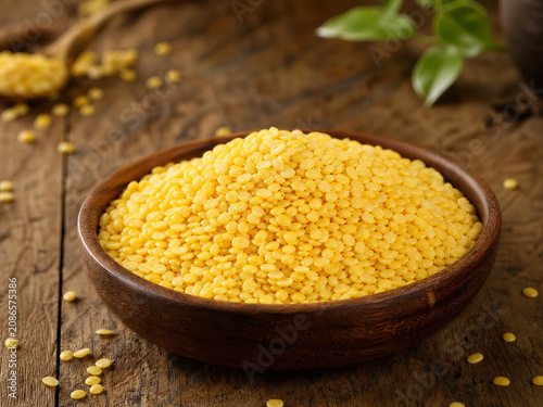 Heap of raw mung beans or moong dal on rustic wooden table.