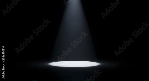 Dramatic white spotlight beam illuminating an empty dark floor in a pitch black studio