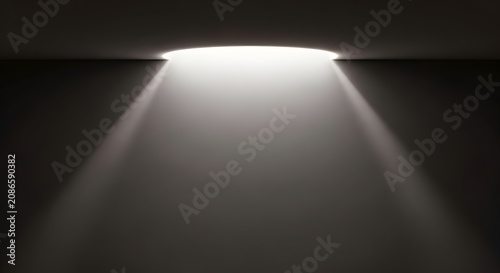 Dramatic circular light beam glowing from above onto a dark wall background in a minimalist room.