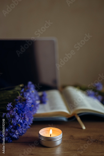 Vászonkép Christian devotional with open Bible, candle and cornflowers.