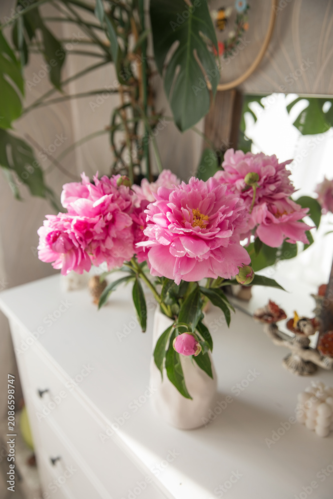 Fototapeta premium A bouquet of beautiful peonies in a home interior