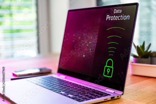 A laptop displays data protection on a wooden desk indoors