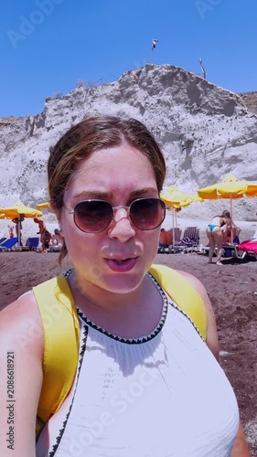 Influencer vlogging on red beach in santorini greece