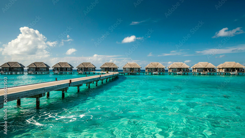 Fototapeta premium Wide angle view of tropical overwater bungalows in turquoise ocean