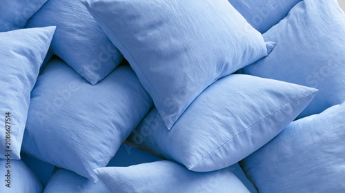 Soft blue pillows arranged in a layered composition, showcasing various sizes and orientations, creating a visually appealing top view display of textured fabric