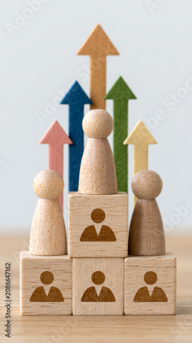 Wooden blocks with icons represent team roles in project management strategy, with colorful arrows symbolizing growth, leadership, and successful teamwork in business environment