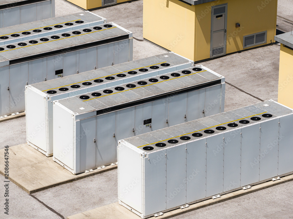 Fototapeta premium Battery energy storage system BESS installation shows several storage units in a row. The scene captures the layout of the system.