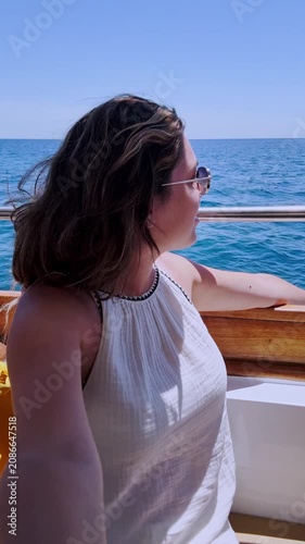 Vlogger woman taking selfie on a boat in santorini, greece