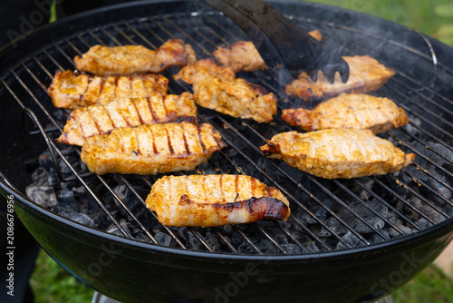 meat is being cooked on the barbecue. A light smoke is spreading over it