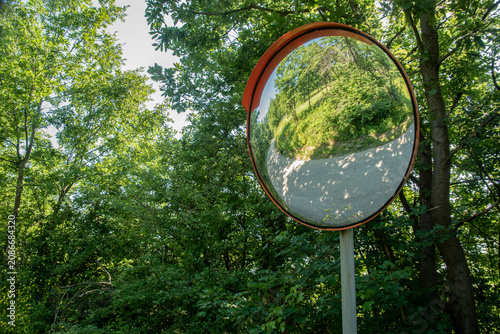 Obraz na plátne Roadside convex mirror helping drivers see approaching traffic on a narrow forest road