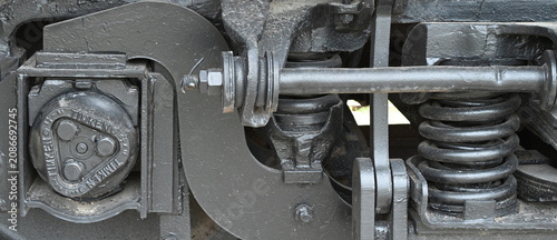 Foto Horizontal close up of a black painted steel train wheel assembly with coil spri