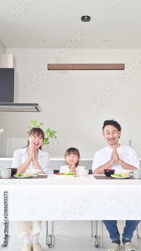 [音声付き いただきます]いただきますをしてダイニングで座る食事を始める親子3人の家族・食育や家族団らんのカメラ目線イメージクローズアップ縦動画