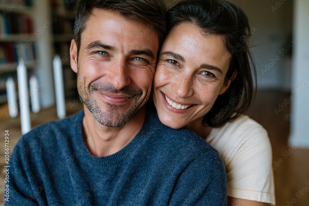 Fototapeta premium Closeup smiling couple at home showing affection and warmth for romantic banner design and cozy relationship background