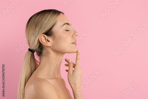 Obraz na plátně Young beautiful woman in side profile touching her chin with eyes closed, posing