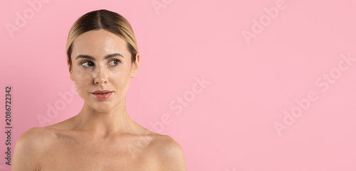 Cuadro en lienzo Young beautiful woman looking aside in minimal beauty portrait on pink studio ba