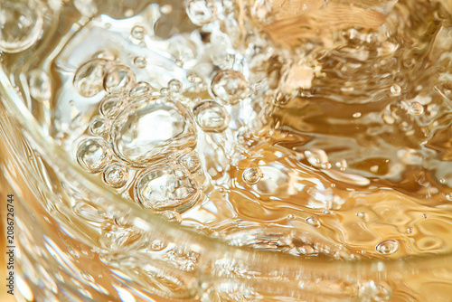 Foto Abstract macro shot of golden carbonated liquid with sparkling bubbles
