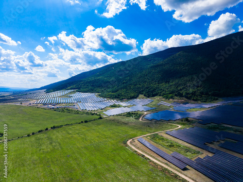 Canvastavla Solar panels cover a large area on a hillside under a clear blue sky with white