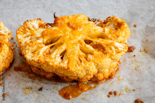 Close-up of golden-brown roasted cauliflower steaks in a baking tray