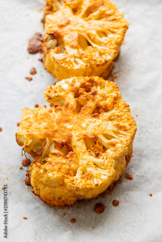 Close-up of golden-brown roasted cauliflower steaks in a baking tray