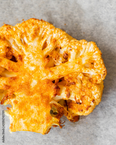 Close-up of golden-brown roasted cauliflower steaks in a baking tray