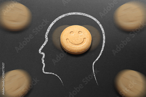 Human head silhouette filled with MDMA or Ecstasy pills on black background