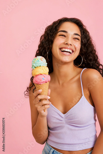 Happy young woman holding colorful triple scoop ice cream cone