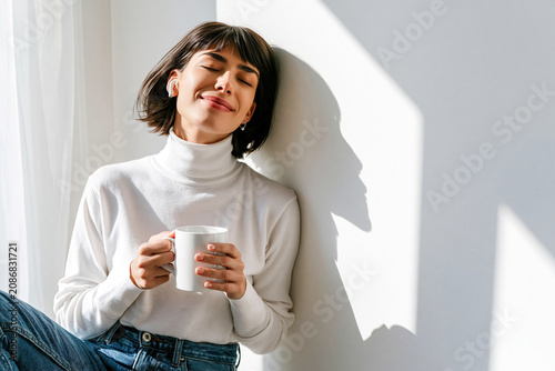 Joyful moments of sipping warm coffee in a cozy sunlit corner during a peaceful morning at home