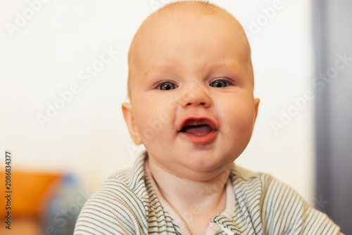 Fotografie Happy baby with a cheerful expression in a bright indoor setting