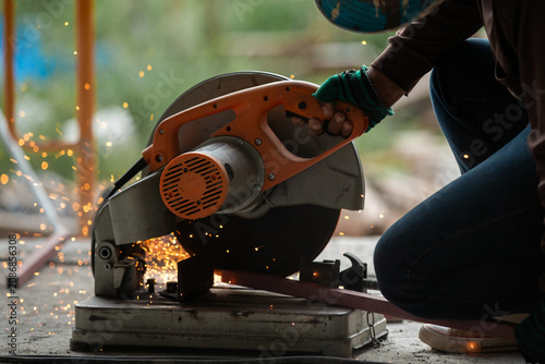 Obraz na płótnie Skilled worker operating a power saw in a construction site sparks flying amidst