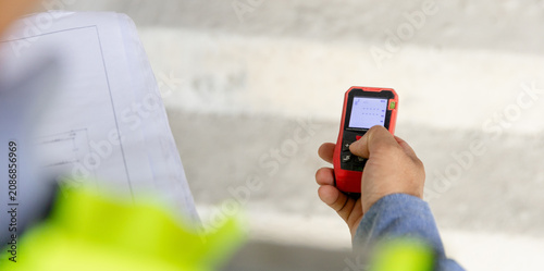 Photos Construction manager utilizing a mobile device to oversee project management on