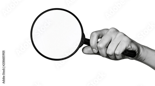 Hand holding magnifying glass over white space