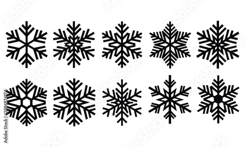 Fotografie Ten black snowflake silhouettes on white background, brightly lit to create a festive and elegant winter atmosphere