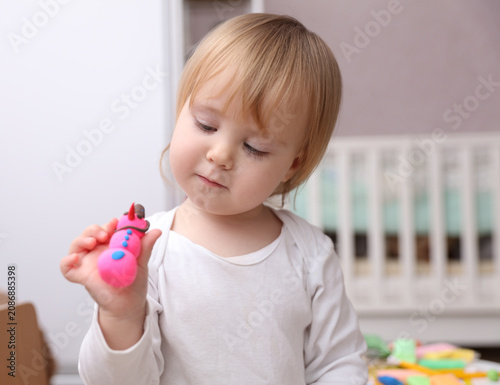 Little baby plays with plasticine. Children's creativity. Motor skills development.
