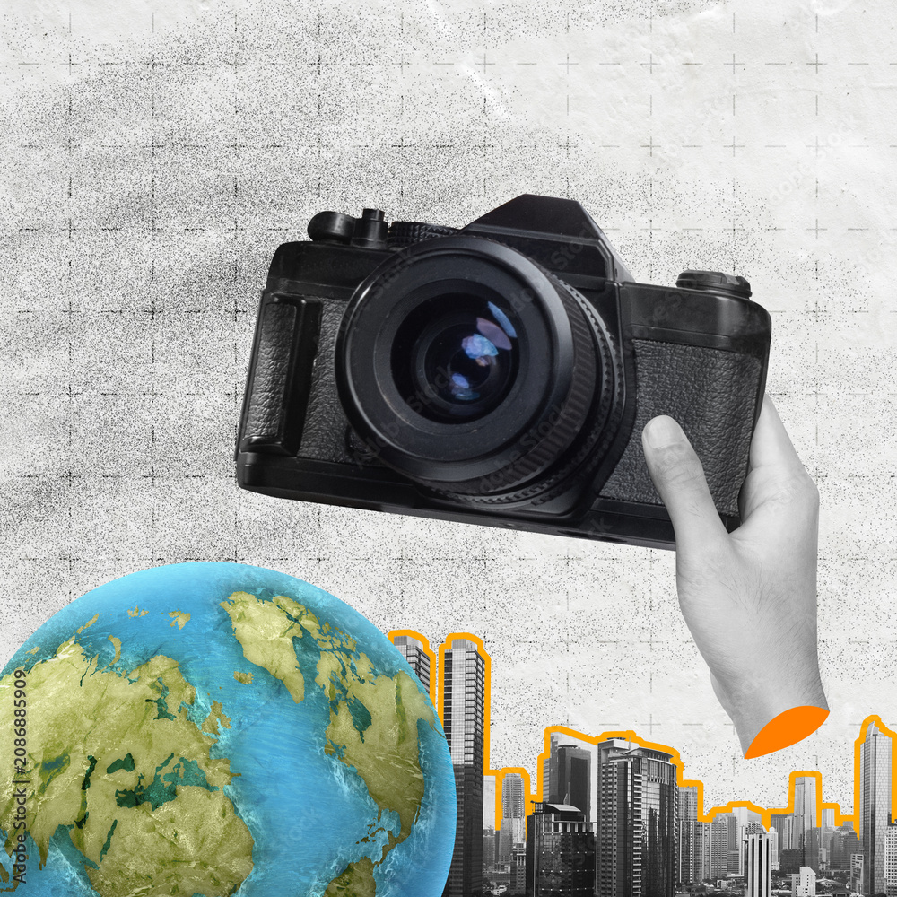 Naklejka premium Surreal collage featuring a hand holding a vintage camera over a globe and city skyline, representing global travel, journalism, and urban exploration