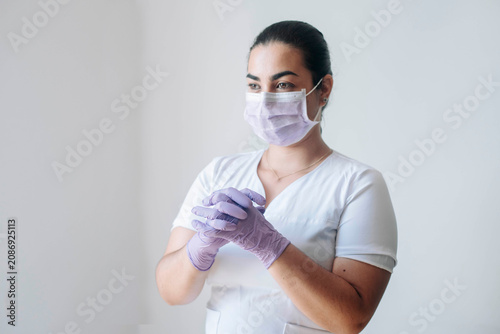 Full-length portrait of a healthcare professional wearing protective equipment in a modern medical clinic.