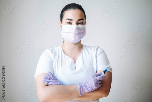 Full-length portrait of a healthcare professional wearing protective equipment in a modern medical clinic.
