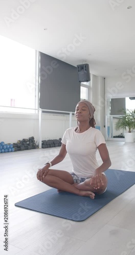 Vertical video: Adult woman eyes closed, breathing on blue mat, hands on chest, belly calming