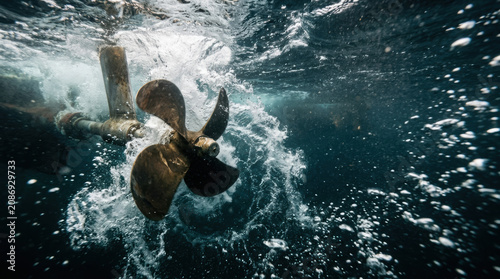 Underwater boat propeller spinning water splash motion marine metal dynamic energy power closeup dramatic scene