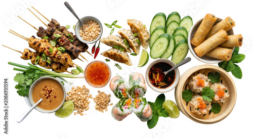 Delicious southeast asian street food spread with grilled meat skewers, spring rolls, and fresh vegetables on a white background.