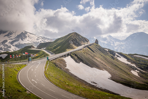 Tableau sur toile The Grossglockner High Alpine Road, a renowned mountain pass featuring European flags and remnants of snow on the peaks