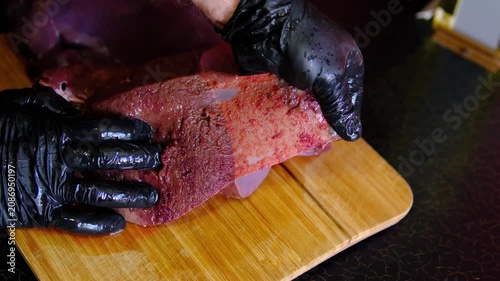to peel the beef liver. woman hands delicately peel away the packaging from beef liver, signifying the beginning of a culinary journey. The texture and freshness evoke anticipation for delicious