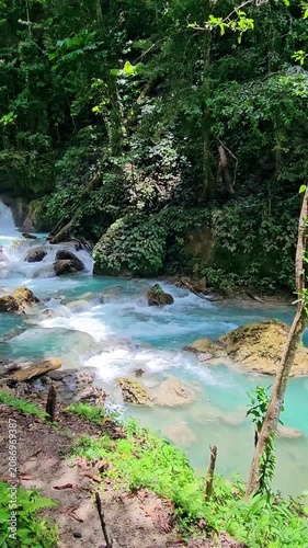 Cascade river with turquoise water in natural pools in sunny rain forest. Luwuk, Indonesia