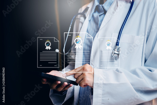 Healthcare certification concept. Doctor using smartphone with digital document badges for medical compliance, approval, and quality assurance