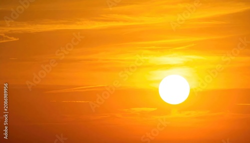 Sunset scene with bright sun and vibrant orange sky and clouds