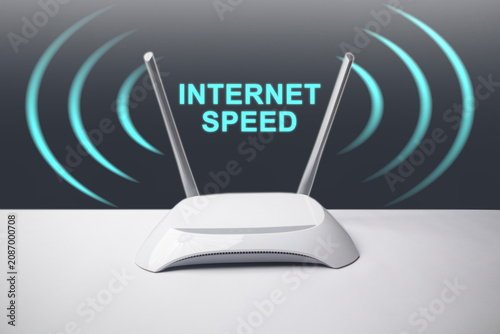 A conceptual image featuring a minimalist white wireless internet router with two antennas, surrounded by glowing blue signal waves and the overlay text INTERNET SPEED.