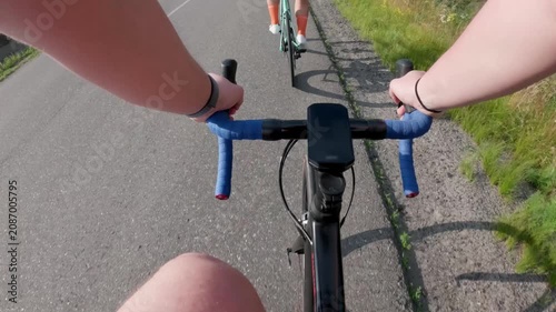 First-person POV of cyclist riding road bike on countryside path, hands gripping blue handlebars, sunny day outdoor fitness lifestyle footage
