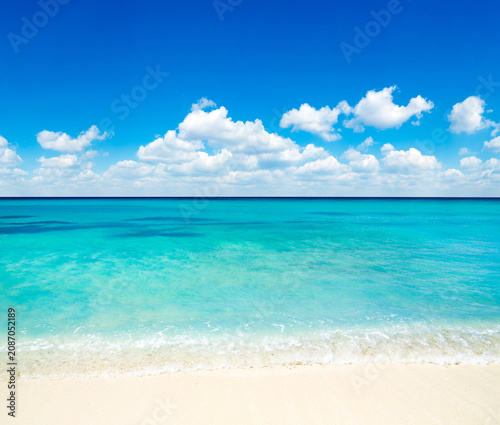 Beach and beautiful tropical sea. Blue sky and white clouds.